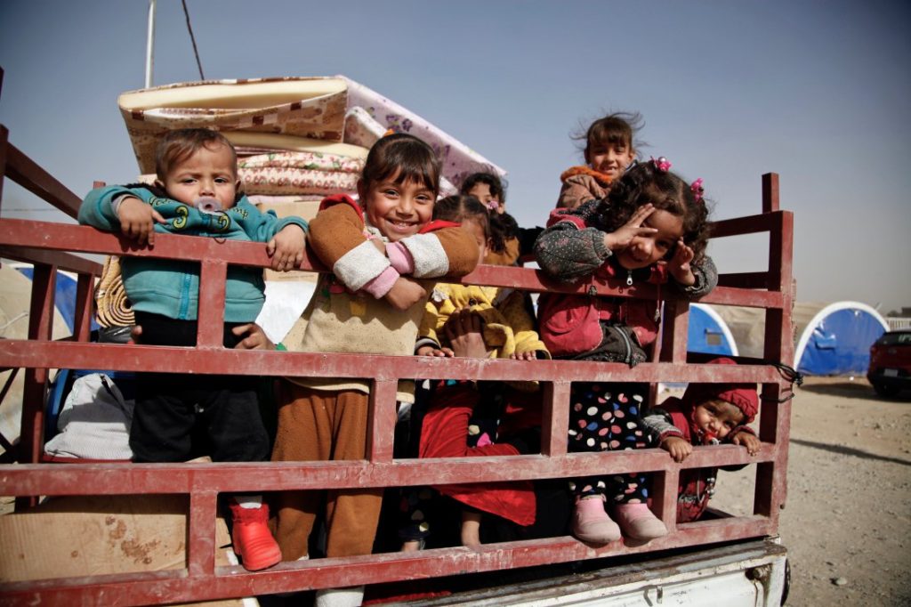 November 20, 2016. Qayyarah, Iraq. Children stand in the back of a truck as their family prepares to return home from Qayyarah Jad’ah camp.