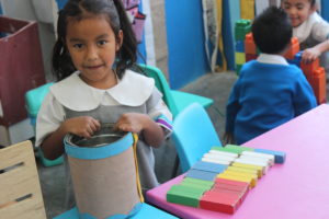 Melany playing with blocks, getting ready to build a “robot”.
