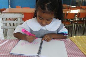 Melany shows how she’s learned to write her name.