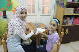 Gehad drawing with Hager, a girl in a sponsorship-supported school.