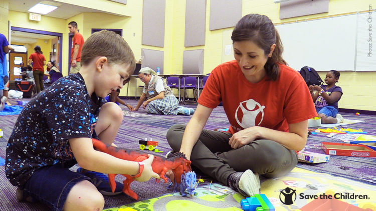 A Save the Children staffer plays with a child in a safe play space, set up to help children cope with the devastating effects of Hurricane Michael.